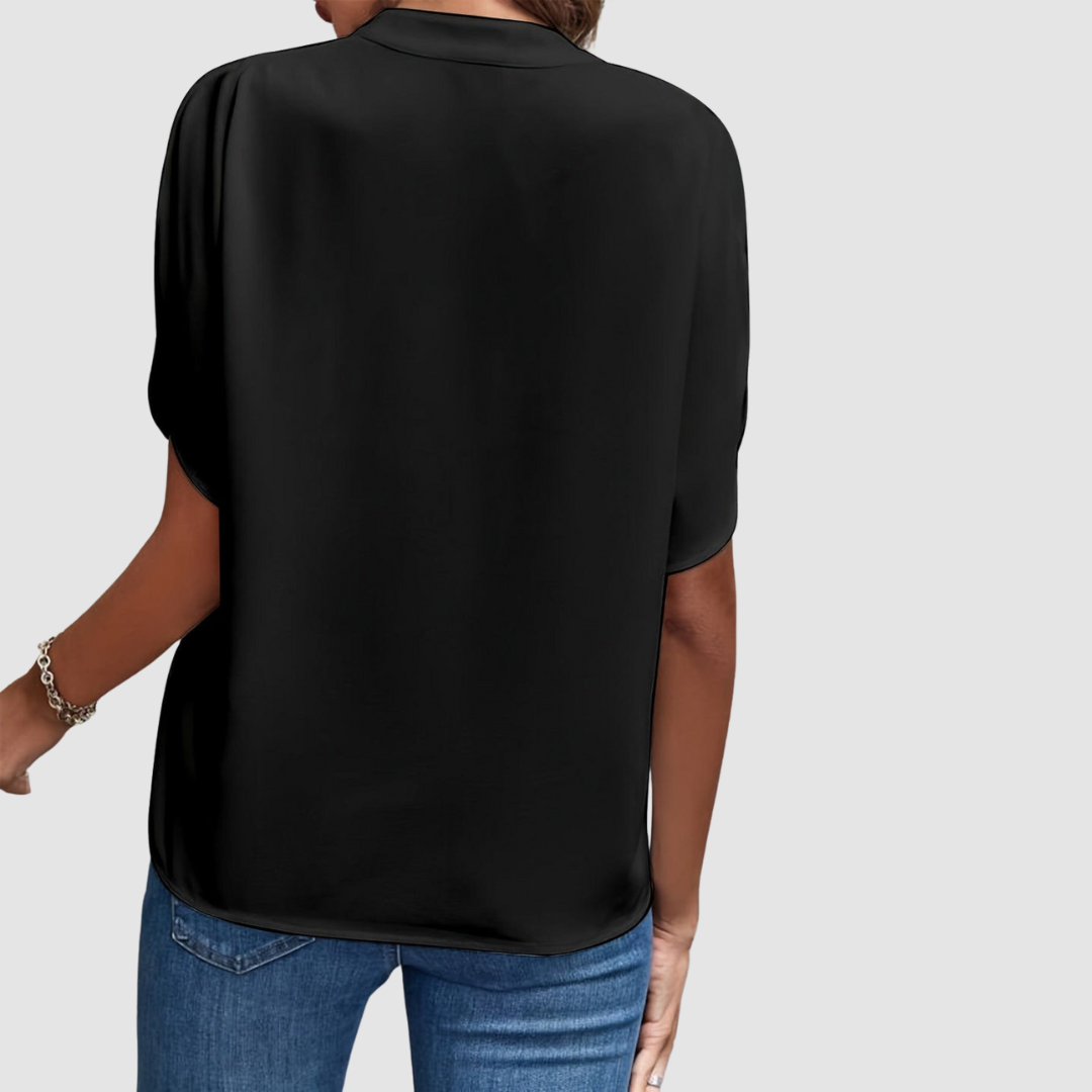 Black draped blouse back view with short dolman sleeves and flowing drape
