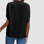 Black draped blouse back view with short dolman sleeves and flowing drape