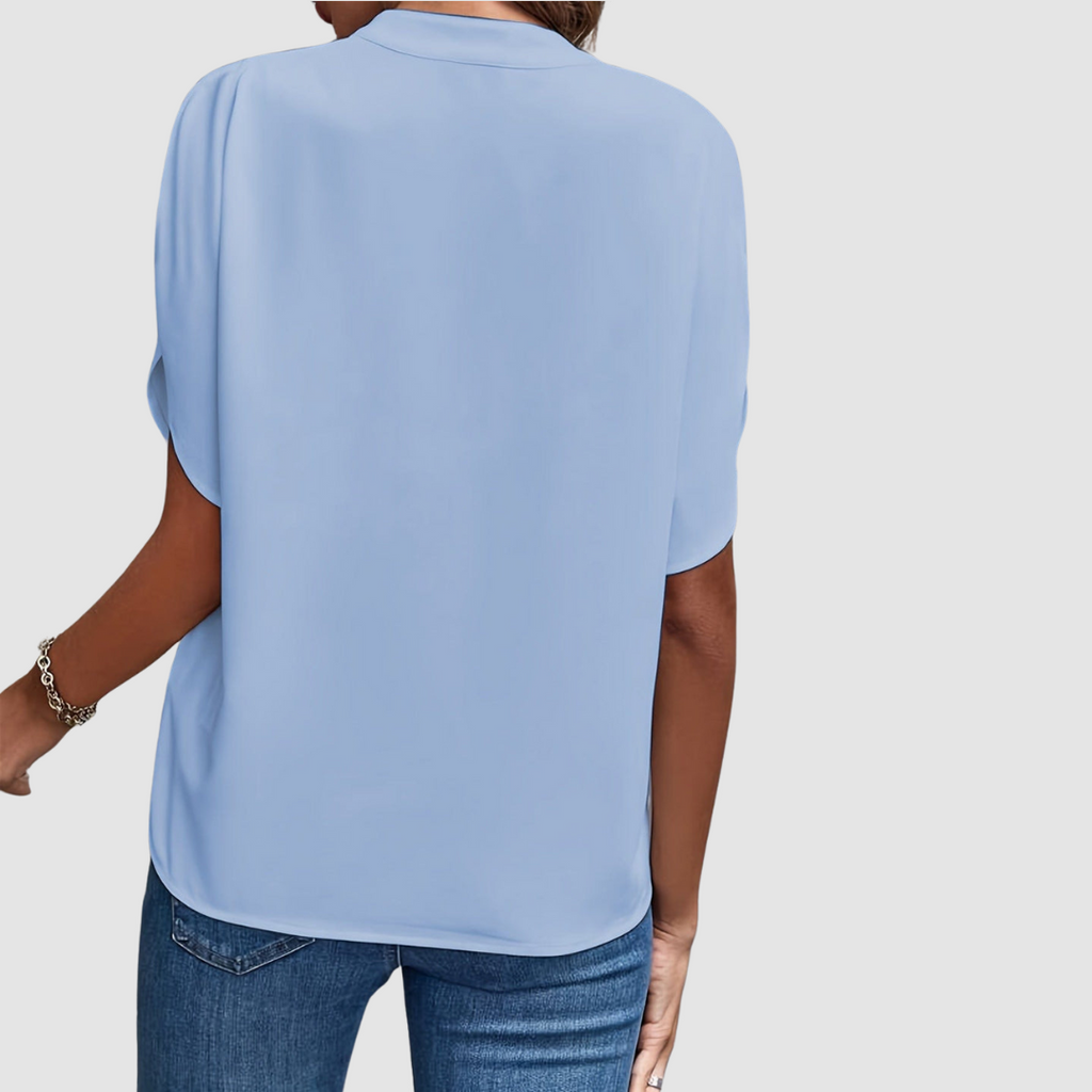 Blue draped blouse back view with short dolman sleeves and flowing drape