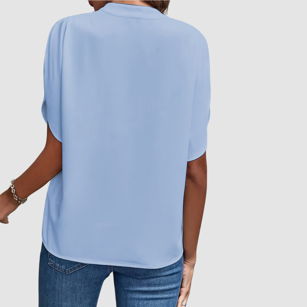 Blue draped blouse back view with short dolman sleeves and flowing drape
