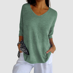 Light green knit v-neck top with three-quarter sleeves and loose draped fit.