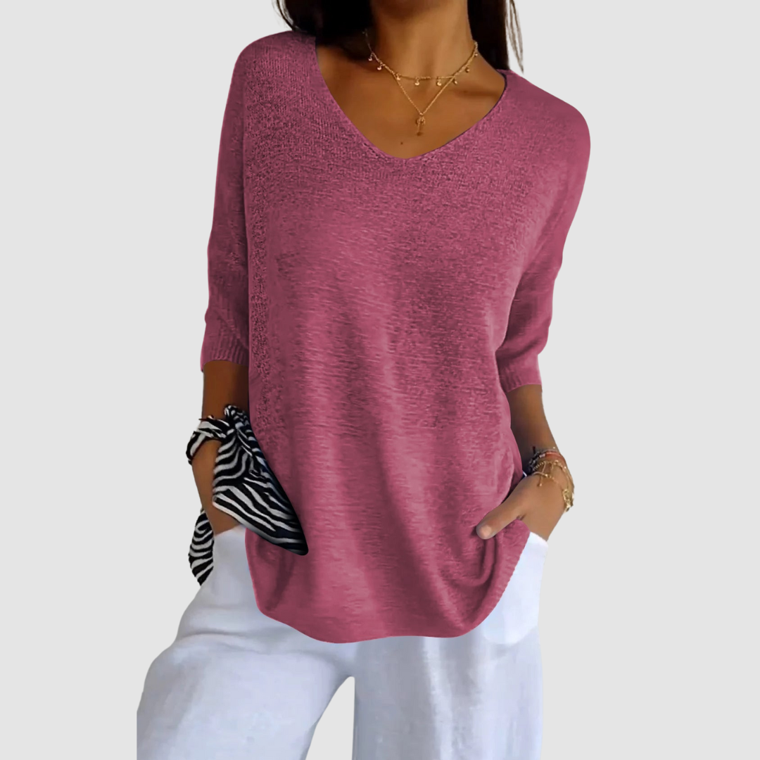 Pink knit v-neck top with three-quarter sleeves and relaxed draped silhouette.