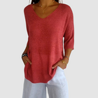 Red knit v-neck top with three-quarter sleeves and relaxed draped fit.