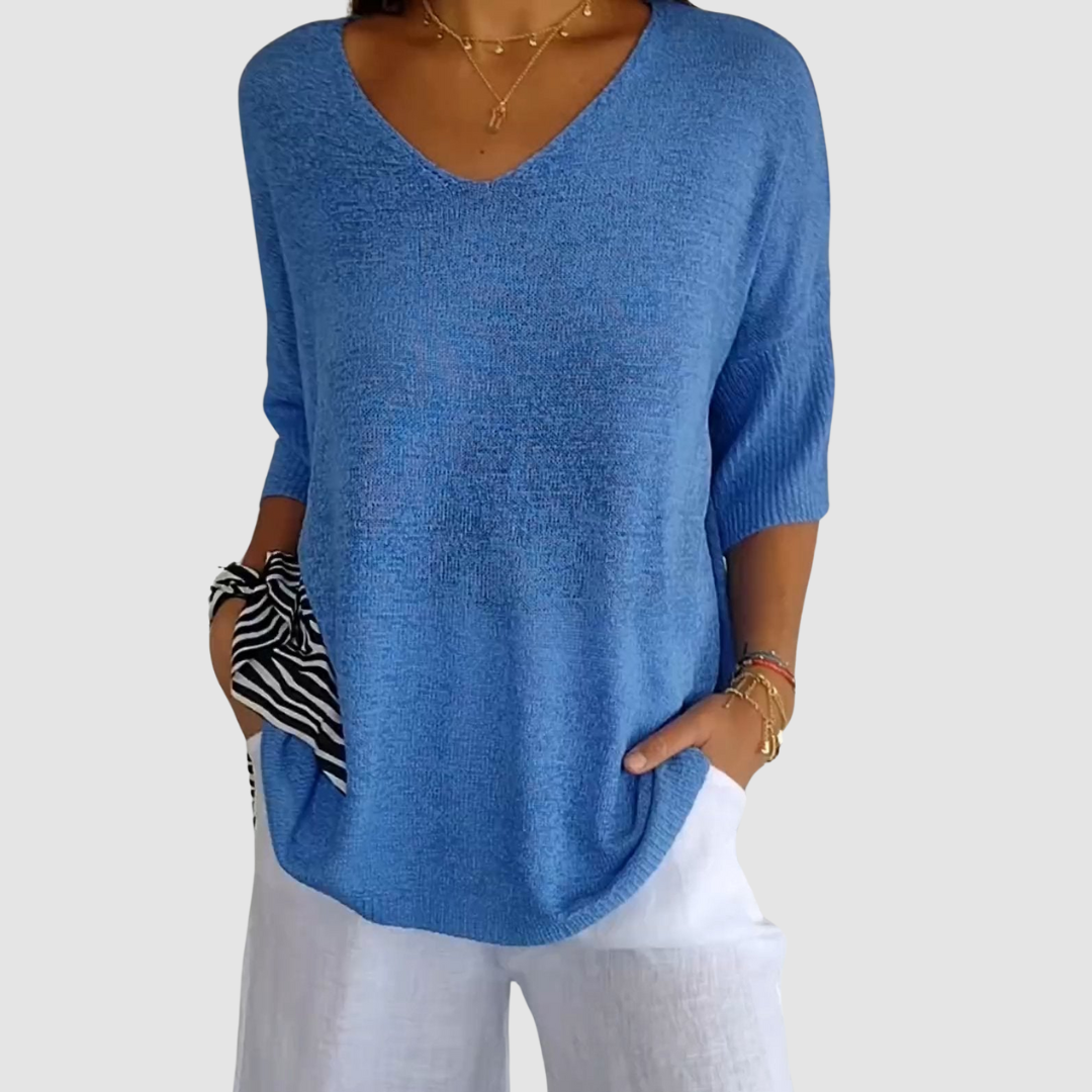Blue knit v-neck top with elbow-length sleeves and relaxed draped fit.