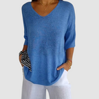 Blue knit v-neck top with elbow-length sleeves and relaxed draped fit.