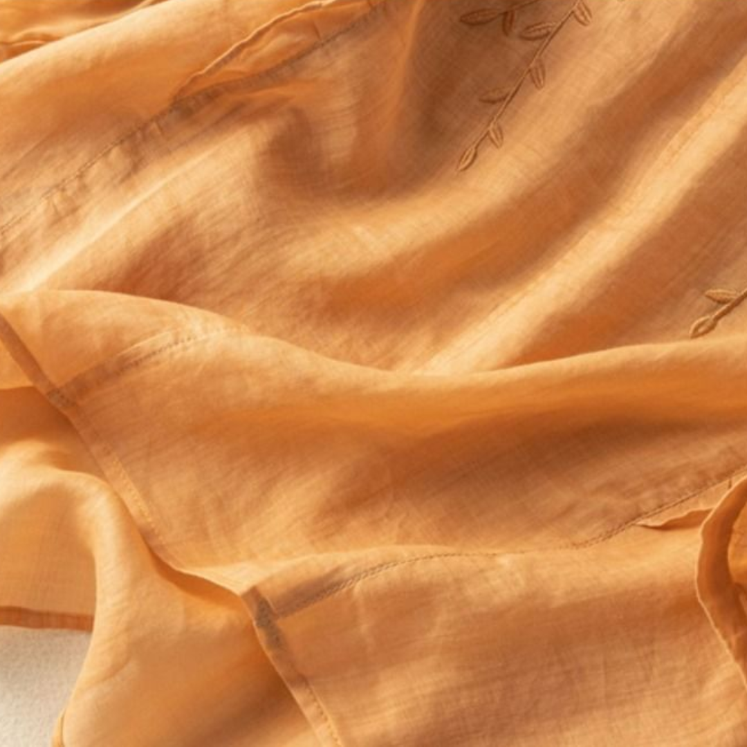 Orange cotton-linen fabric with subtle leaf embroidery