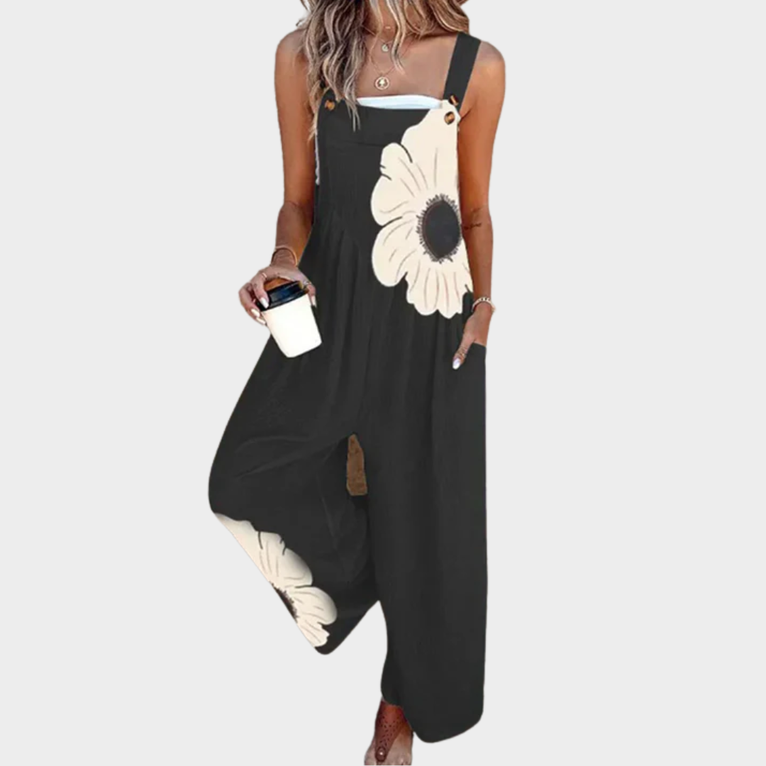 Black sleeveless jumpsuit with daisy print, wide legs, and button-accent straps