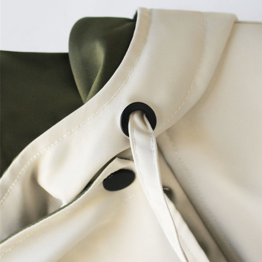 Windbreaker collar detail in off-white with snap closure and black loop accent