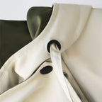 Windbreaker collar detail in off-white with snap closure and black loop accent