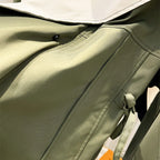 Olive green windbreaker jacket front with button placket and drawstring hood opening