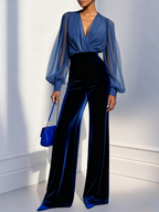Blue velvet long-sleeve jumpsuit with V-neck and sheer mesh sleeves, front standing