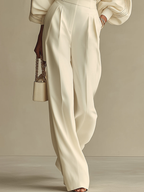 Ivory high-waisted wide-leg pants with pleated front, paired with crewneck top