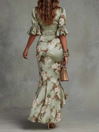 Sage green floral satin maxi dress, back view with ruched waist and flared sleeves