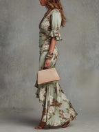 Sage green floral satin maxi dress, side view with ruched waist and asym ruffle hem