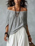 Grey off-shoulder draped top over white gathered lantern pants