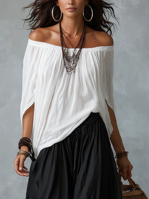 White off-shoulder draped top with black lantern pants set, close front