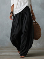White off-shoulder top with black ruched lantern pants, walking view