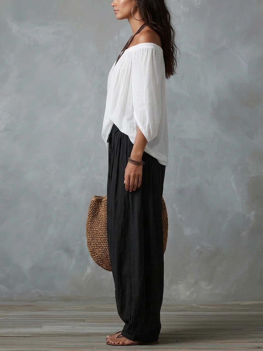White off-shoulder top with black loose lantern pants, side view