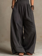 Charcoal pinstripe wide-leg jumpsuit with smocked waist and flowing palazzo legs