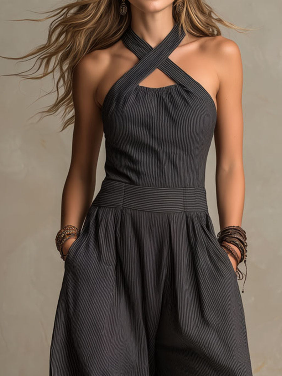 Charcoal pinstripe halter jumpsuit with crisscross neckline and pleated wide-leg design
