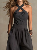 Charcoal pinstripe halter jumpsuit with crisscross neckline and pleated wide-leg design
