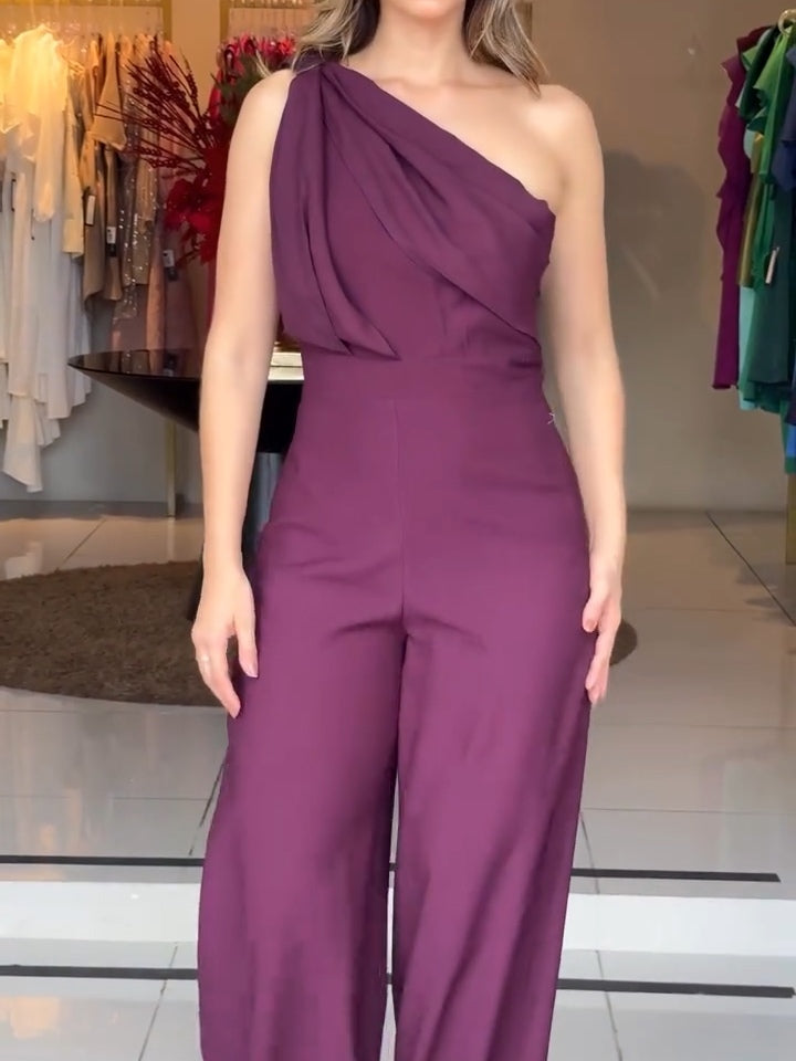 Purple one-shoulder jumpsuit with diagonal sash drape and relaxed wide-leg fit