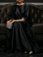 Black satin maxi dress, flowing fabric with bracelet-length drape and wide sleeves