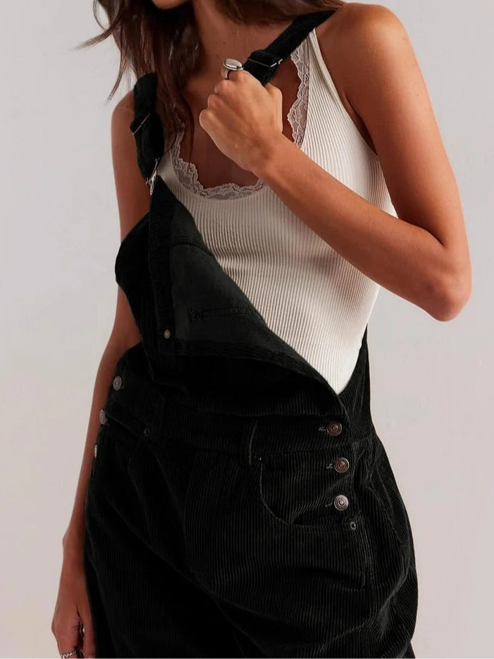 Black corduroy workwear jumpsuit with front bib, adjustable straps, button pockets