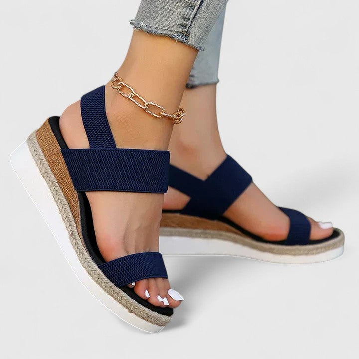 Navy orthopedic sandals with wide hook-and-loop straps and jute wedge sole.