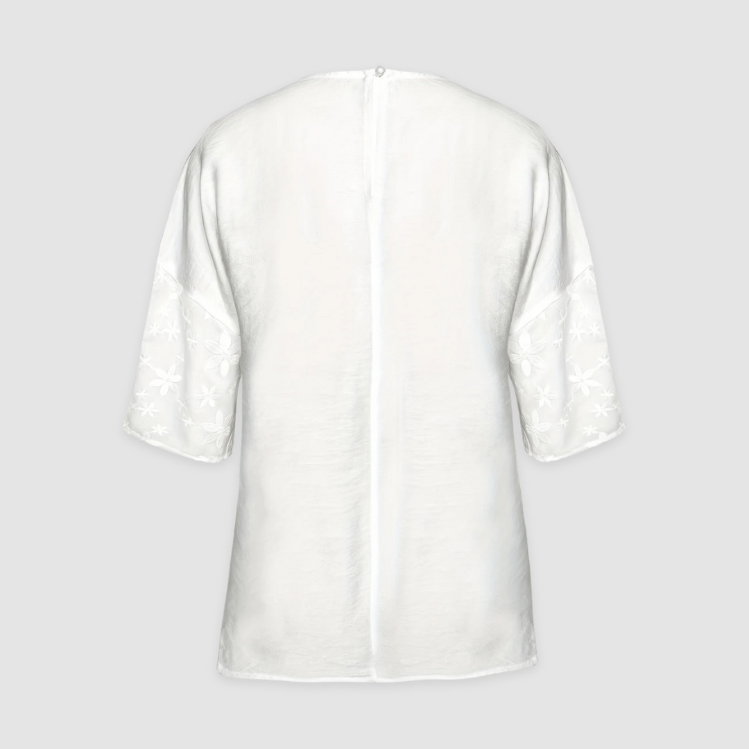 White loose-fit shirt with floral cuffs and buttoned back opening
