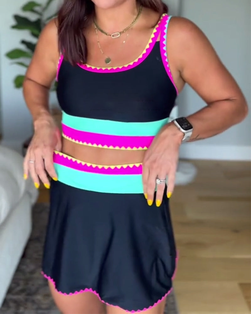 Color-block three-piece swimsuit, black with pink and teal stripes, scalloped trim.