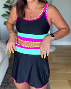Color-block three-piece swimsuit, black with pink and teal stripes, scalloped trim.