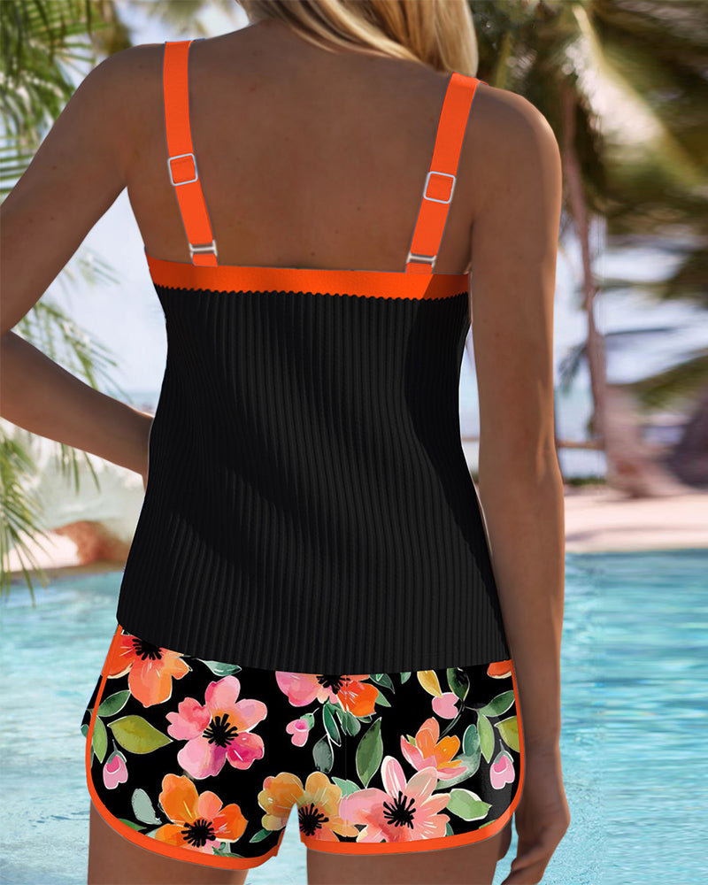 Two-piece beach tankini with black ribbed tank and orange-trimmed floral shorts