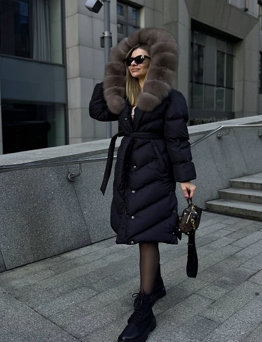 Black puffer coat with taupe fur hood, button closure, and waist tie belt.