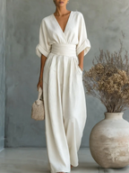 White V-neck high-waist jumpsuit with cinched waist and wide-leg flow, dolman sleeves