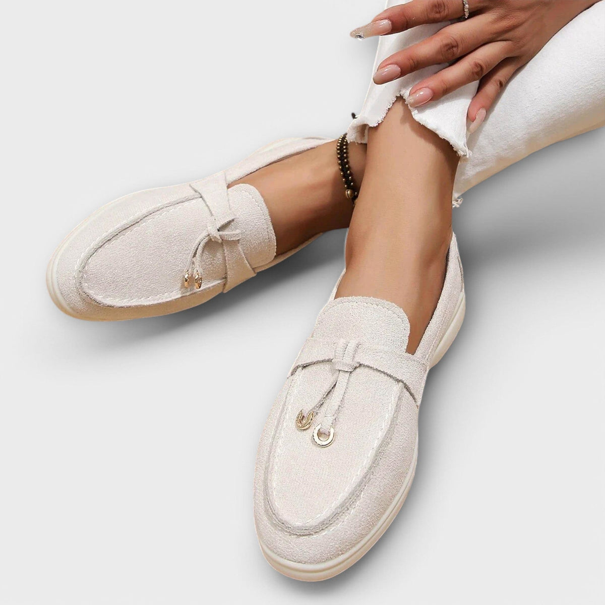 Beige women's suede loafers with tie bow detail and low cushioned sole