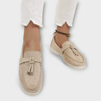 Beige women's suede loafers, side view, with tie bow strap and low sole