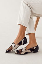 Pair of black and white loafers with low block heel and slip-on fit