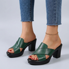 Green orthopedic sandals, side view with wide cross straps and block heel.