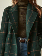 Dark green plaid tweed coat detail: lapel and brown button