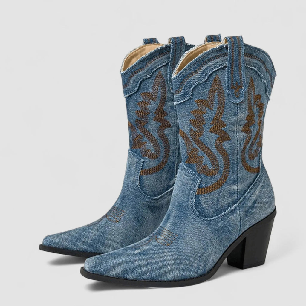 Blue denim ankle boots with brown embroidered swirl and black block heel, front view