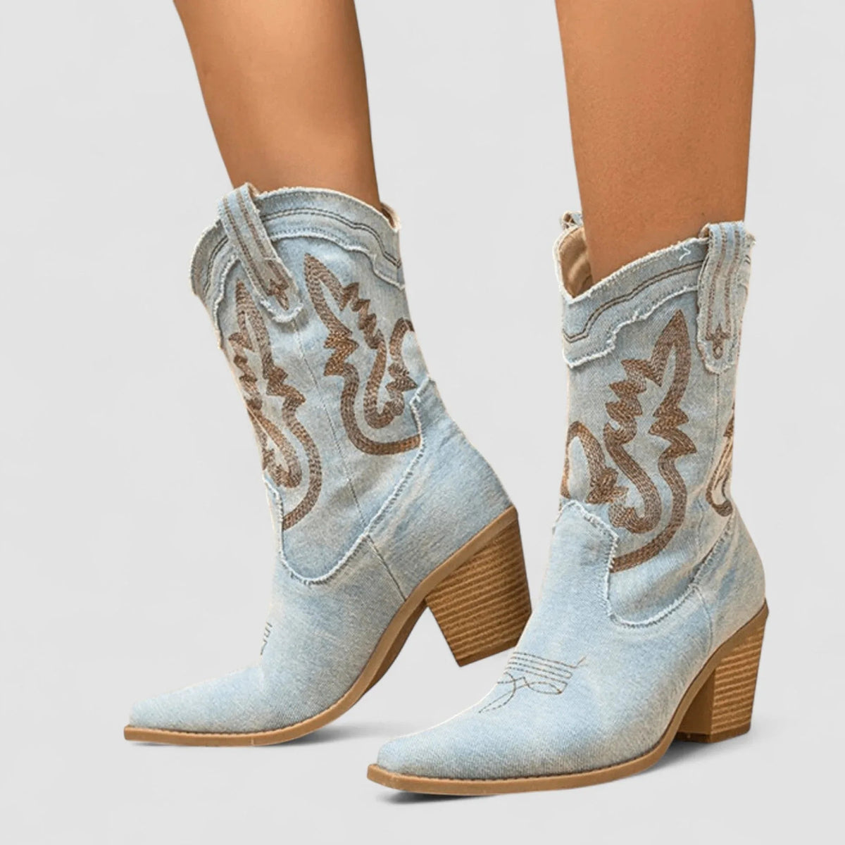 Light blue denim ankle boots with brown embroidered swirl detail and block heel