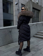Black long puffer jacket with taupe fur hood and belted waist detail.