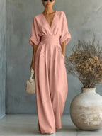 Blush pink V-neck high-waist jumpsuit with cinched waist and wide-leg flow, dolman sleeves