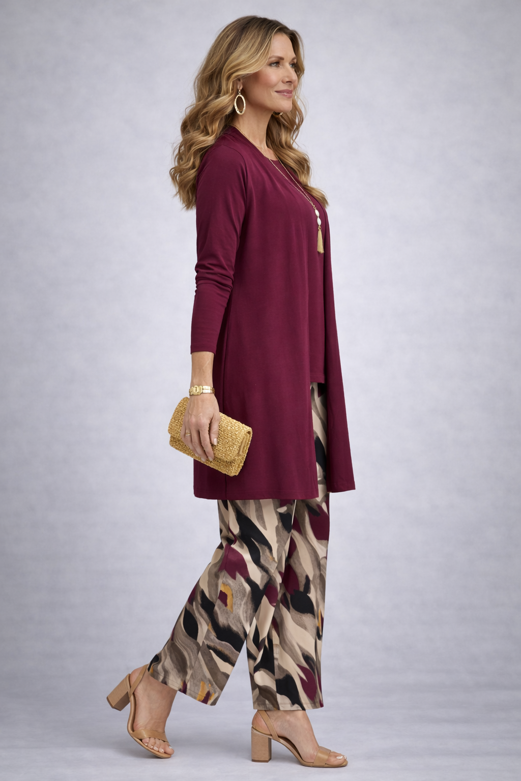 Women's purple 3-piece set: long cardigan, purple top, patterned pants; tan heels.