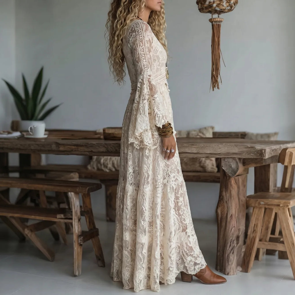 Ivory lace maxi dress in side profile with long sleeves and flowing tiered skirt