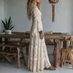 Ivory lace maxi dress in side profile with long sleeves and flowing tiered skirt
