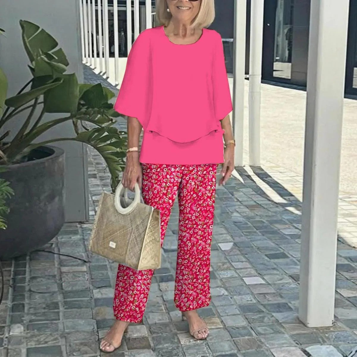 Pink two-piece set: short-sleeve layered top and red floral straight pants