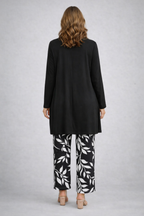 Black long cardigan and top over leaf-print pants, back view