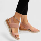 Blush pink orthopedic sandals with wide straps, tan espadrille sole, and gold chain ankle strap